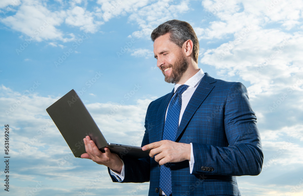 happy business man freelancing outdoor. business man freelancing with laptop wearing suit. happy business man freelancing outdoor. business man freelancing with laptop wearing suit.