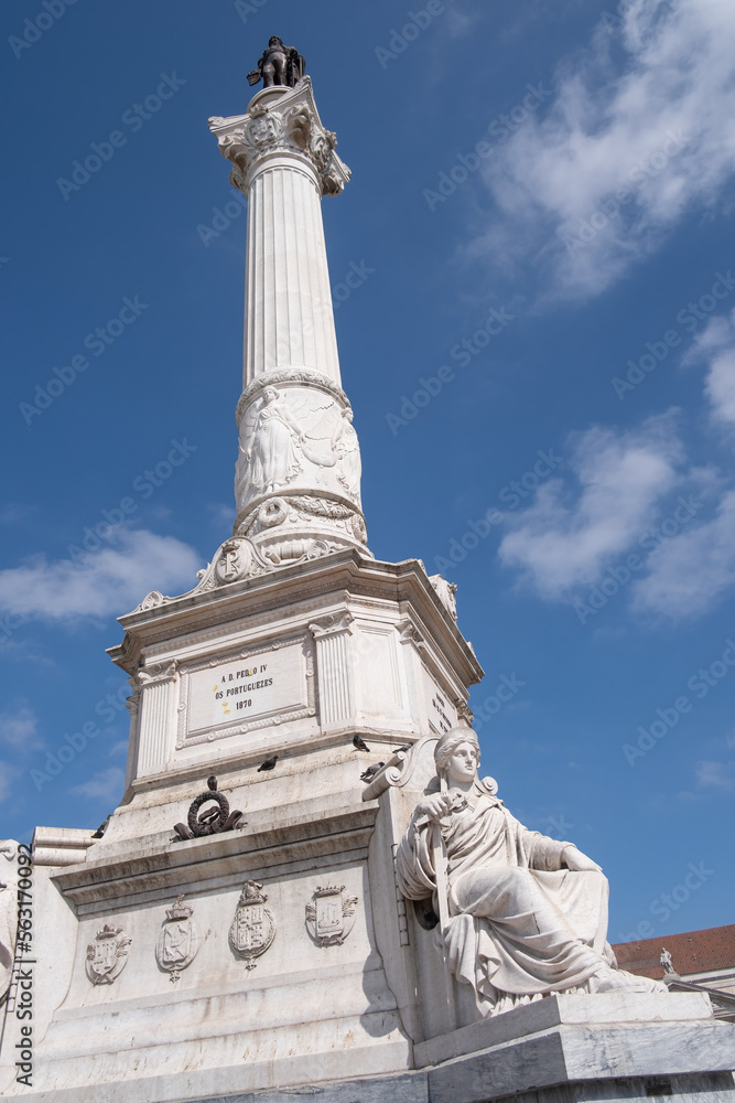 A huge white stone column with a bronze statue of a king of Portugal Pedro IV at the top, seen from below Rossio Square, Lisbon, Portugal, vertical