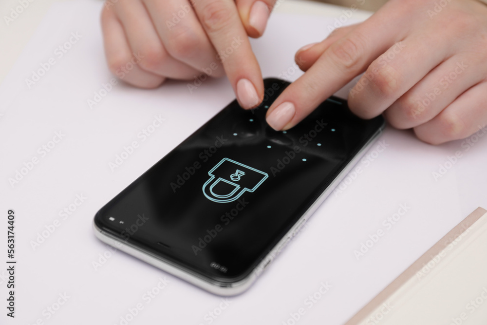 Woman unlocking smartphone with blocked screen at white table, closeup Woman unlocking smartphone with blocked screen at white table, closeup