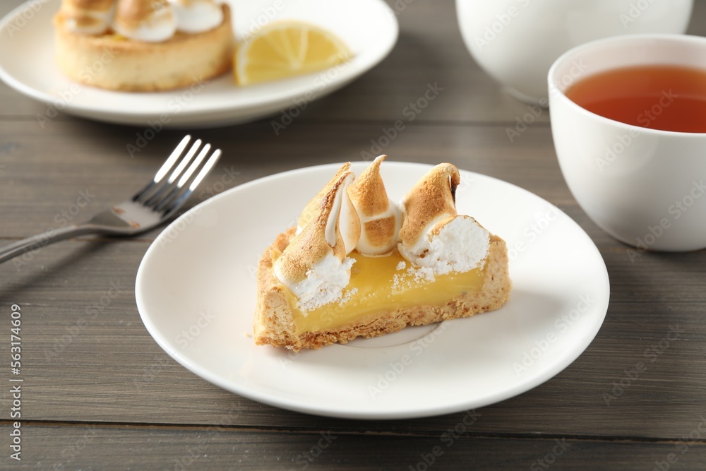 Piece of delicious lemon meringue pie on wooden table Piece of delicious lemon meringue pie on wooden table