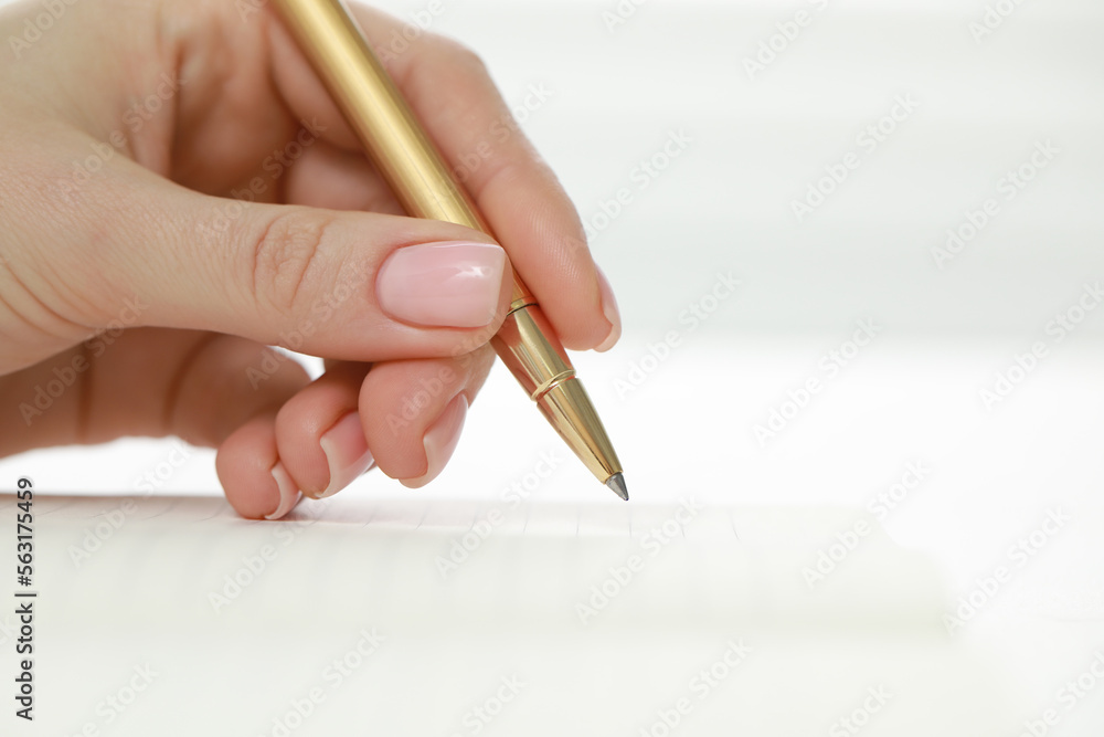 Woman writing in notebook at white table, closeup Woman writing in notebook at white table, closeup