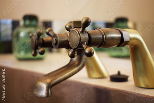 Detail of a vintage faucet placed in the bathroom of a luxury room in a country cottage hotel close to Girona, Catalonia, Spain.