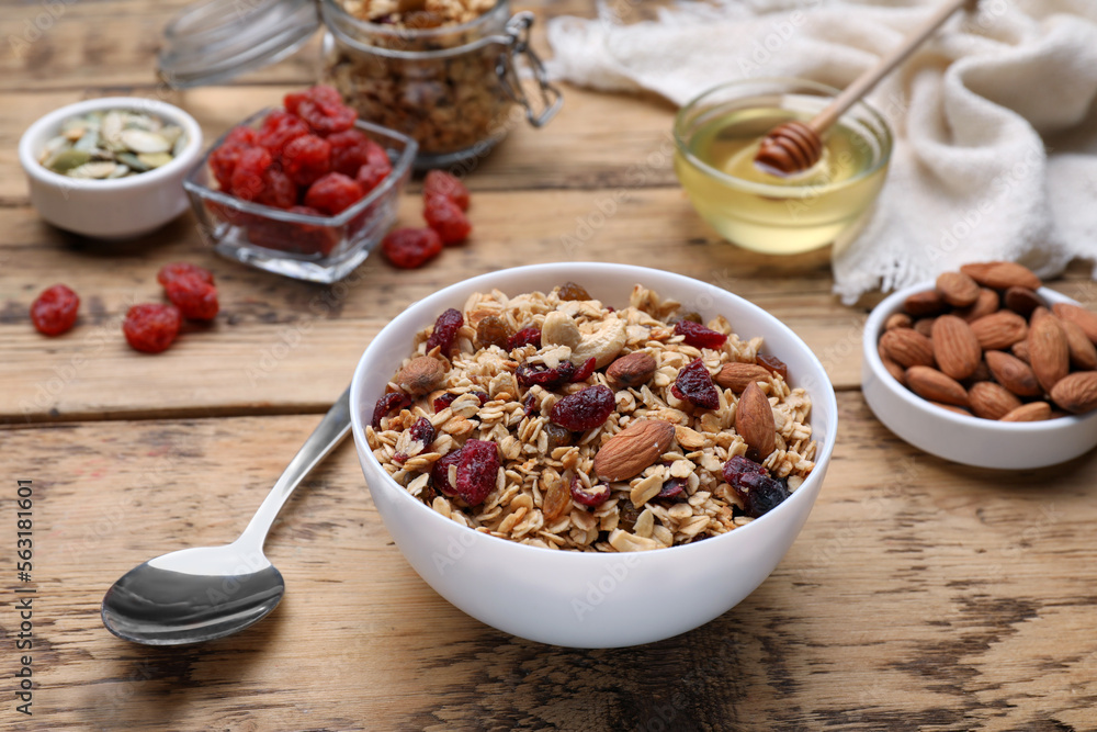Tasty granola served with nuts and dry fruits on wooden table Tasty granola served with nuts and dry fruits on wooden table