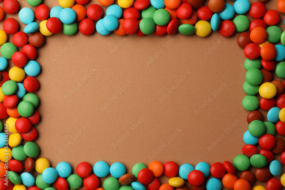 Frame of tasty colorful candies on light brown background, flat lay. Space for text Frame of tasty colorful candies on light brown background, flat lay. Space for text