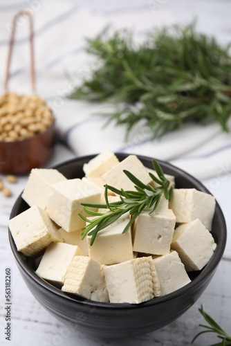 Delicious tofu cheese, rosemary and soybeans on white wooden table, closeup