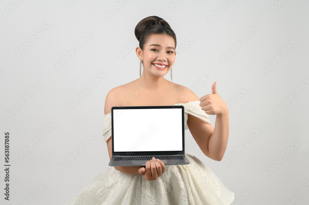 Young asian beautiful bride pose with mockup laptop computer in hand Young asian beautiful bride pose with mockup laptop computer in hand