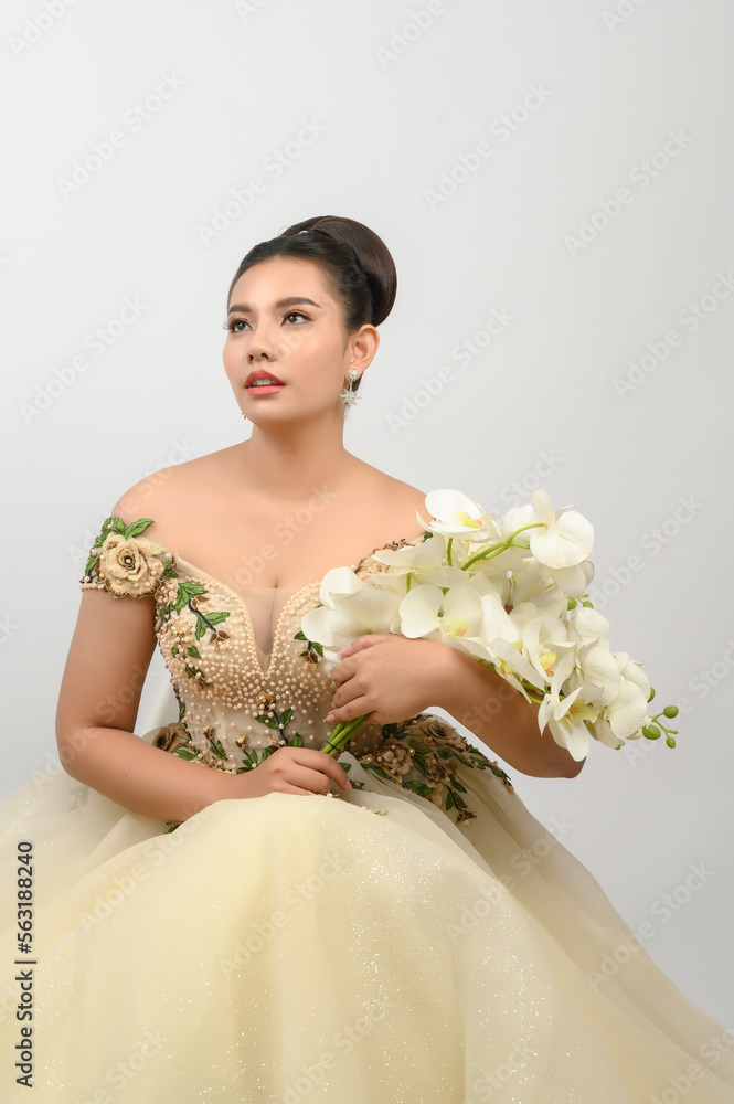 Young asian beautiful bride with orchid bouquet on white background Young asian beautiful bride with orchid bouquet on white background