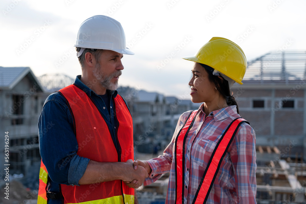 Construction engineer making handshake with foreman, smiling face at real estate site background, agreement successful to work together to develop landscape and utilities in property project. Construction engineer making handshake with foreman, smiling face at real estate site background, agreement successful to work together to develop landscape and utilities in property project.