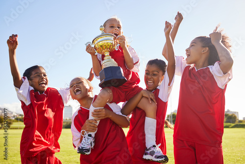 Soccer, team and trophy with children in celebration together as a girl winner group for a sports competition. Football, teamwork and award with soccer player kids celebrating success in sport
