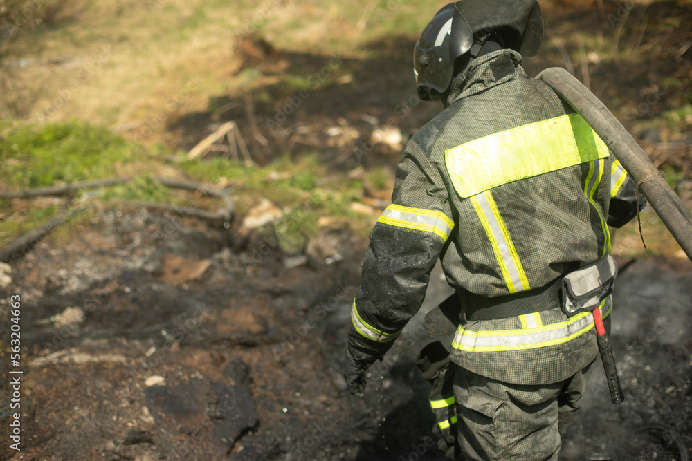 Firefighter puts out fire. Lifeguard pours water from hose. Firefighter puts out fire. Lifeguard pours water from hose.