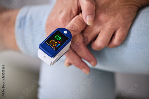 Pulse oximeter, healthcare and woman taking her heart rate in a retirement home during consultation. Medical, treatment and senior female patient measuring her oxygen blood levels with health device.