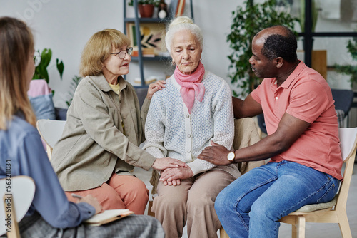 Group of people supporting senior woman while they visiting psychotherapy with psychologist