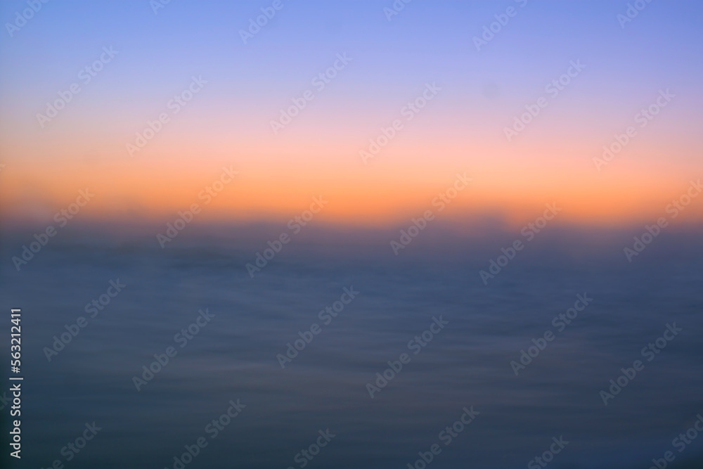 Sunrise horizon over the dark ocean where the sun begins to brighten the sky, retouched and color manipulated image illustration.