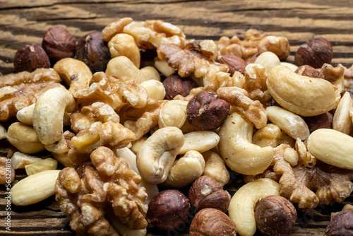 Mix of tasty nuts on a wooden surface. Cashews, almonds, hazelnuts and walnuts on a brown table.