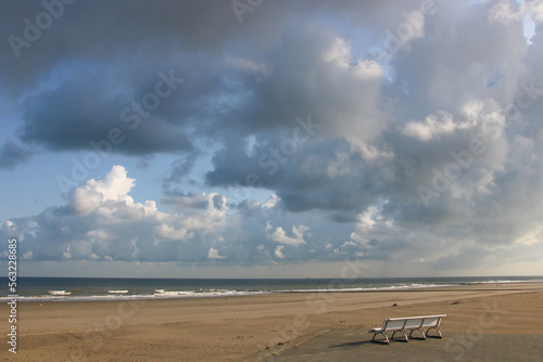 banc sur la plage vide d'Ostende en Belgique devant la mer le matin photo