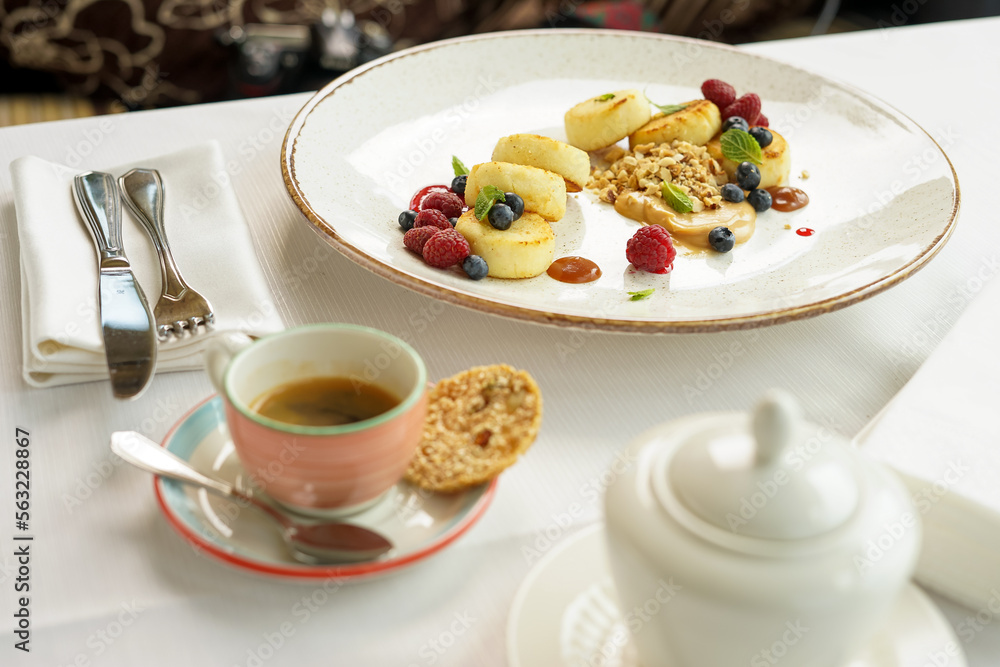 breakfast dessert sweet cheesecakes with berries in a plate on the table with tea
breakfast dessert sweet cheesecakes with berries in a plate on the table with tea