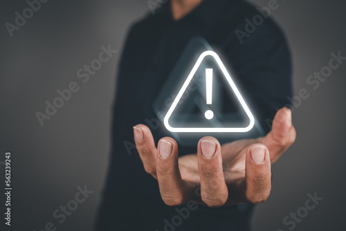 Problem for notification error 404 and maintenance service alarm, Businessman holding glowing of triangle caution warning exclamation sign.
