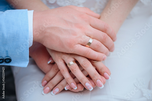 Hands of the bride and groom together. Close-up of the newlyweds  hands holding each other s hands. The hands of the bride and groom with rings. 