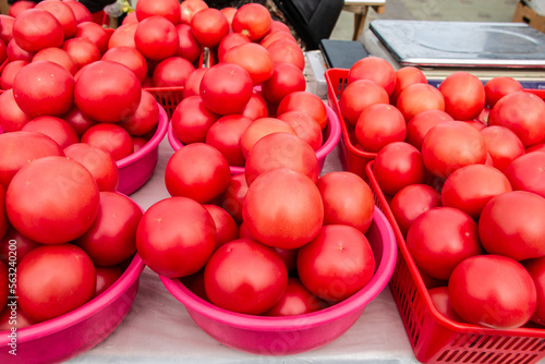 Obraz na płótnie Lots of red tomatoes in plastic on the counter. Sale of tomatoes at the farmers' market. Red ripe tomatoes. w salonie