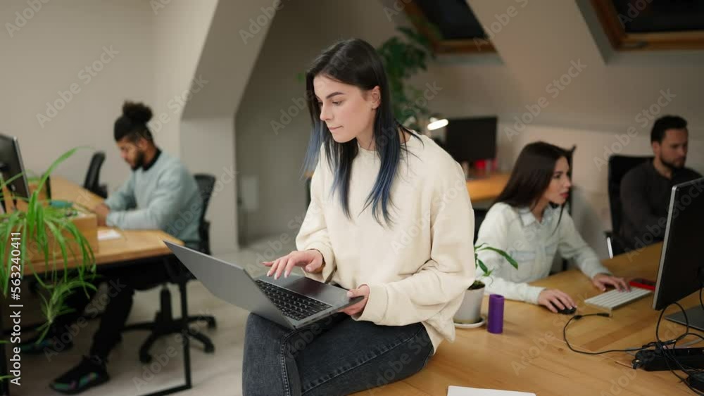 Focused brunette woman sitting on the table with laptop, trying to solve the problem Focused brunette woman sitting on the table with laptop, trying to solve the problem