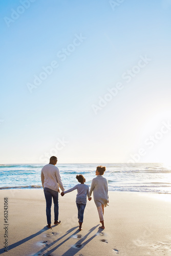 Family, beach and walk during sunset on vacation or holiday relaxing and enjoying peaceful scenery at the ocean. Sea, water and parents with daughter, child or kid with childhood freedom © Reese/peopleimages.com