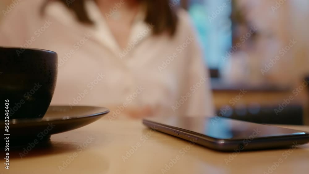 Blur shot of female gesturing while talking in a cafe. Defocused video of an office worker talking while having coffee. Blur shot of female gesturing while talking in a cafe. Defocused video of an office worker talking while having coffee.