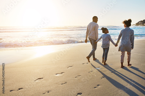 Black family, sunset and beach walk during summer on vacation relaxing at a peaceful scenery by the ocean. Sea, footprints and parents with daughter, child or kid with childhood freedom