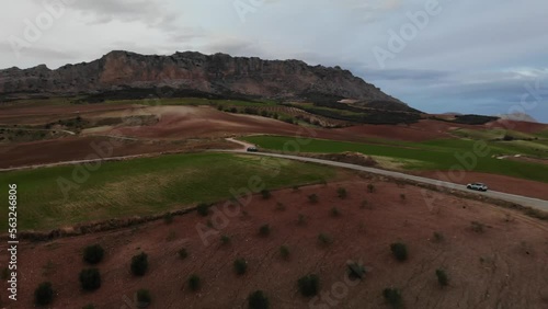 4K sunset drone footage over cars driving through road with fields and mountains on the back at Torcal mountain, Antequera, Malaga, Spain.
Mid angle, panoramic movement.