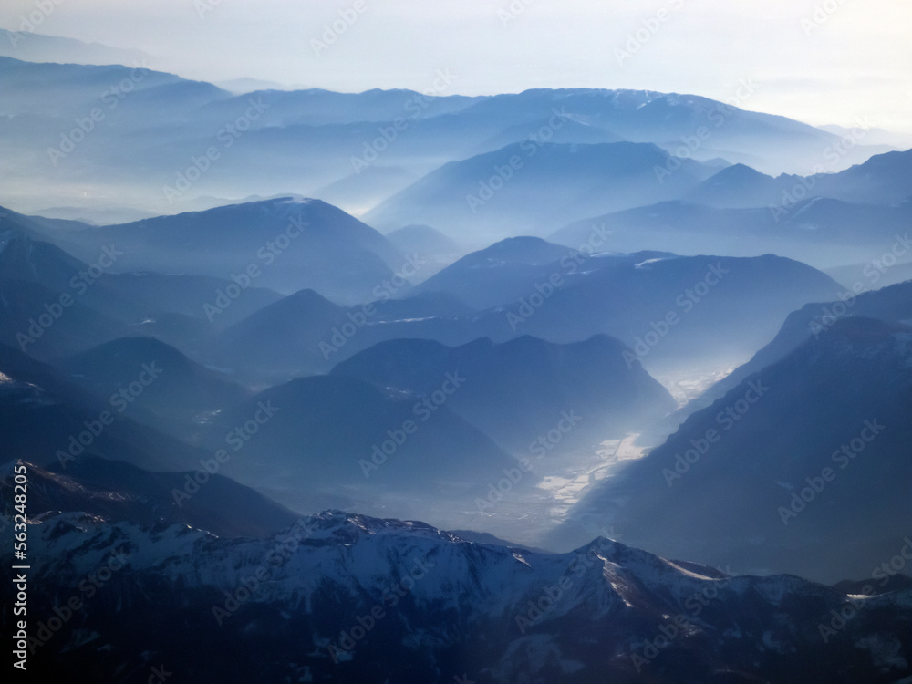 Mountains in the haze. View of the beautiful high mountains from the plane.