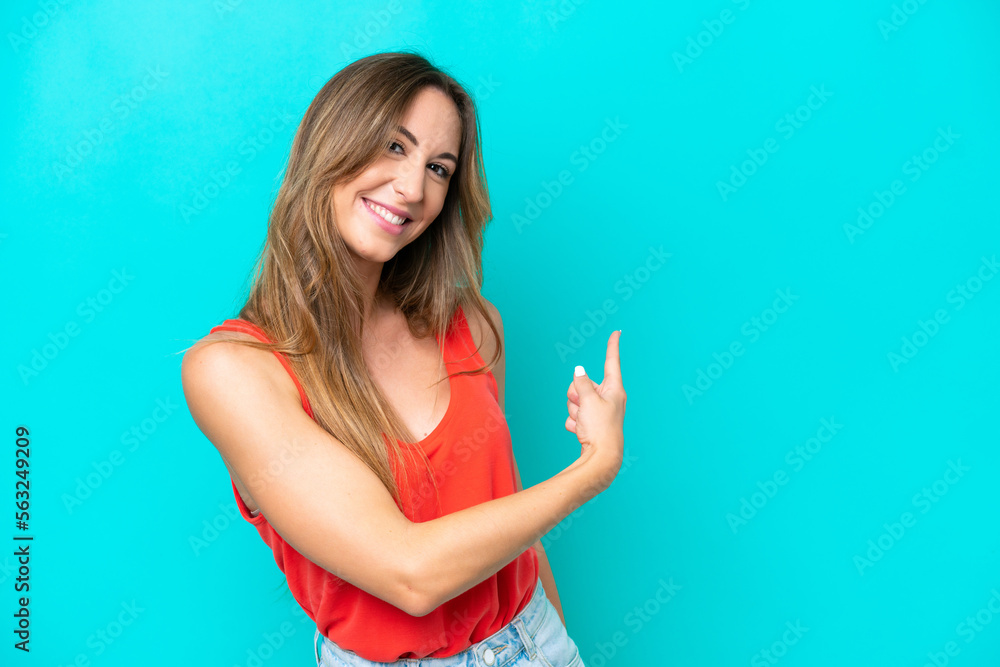 Young caucasian woman isolated on blue background pointing back Young caucasian woman isolated on blue background pointing back