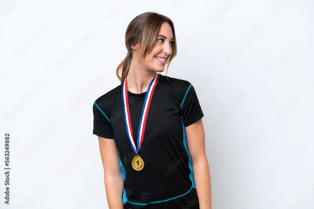 Young caucasian woman with medals isolated on white background looking side Young caucasian woman with medals isolated on white background looking side