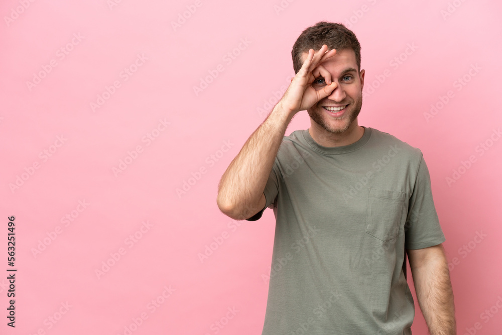 Young caucasian man isolated on pink background showing ok sign with fingers Young caucasian man isolated on pink background showing ok sign with fingers