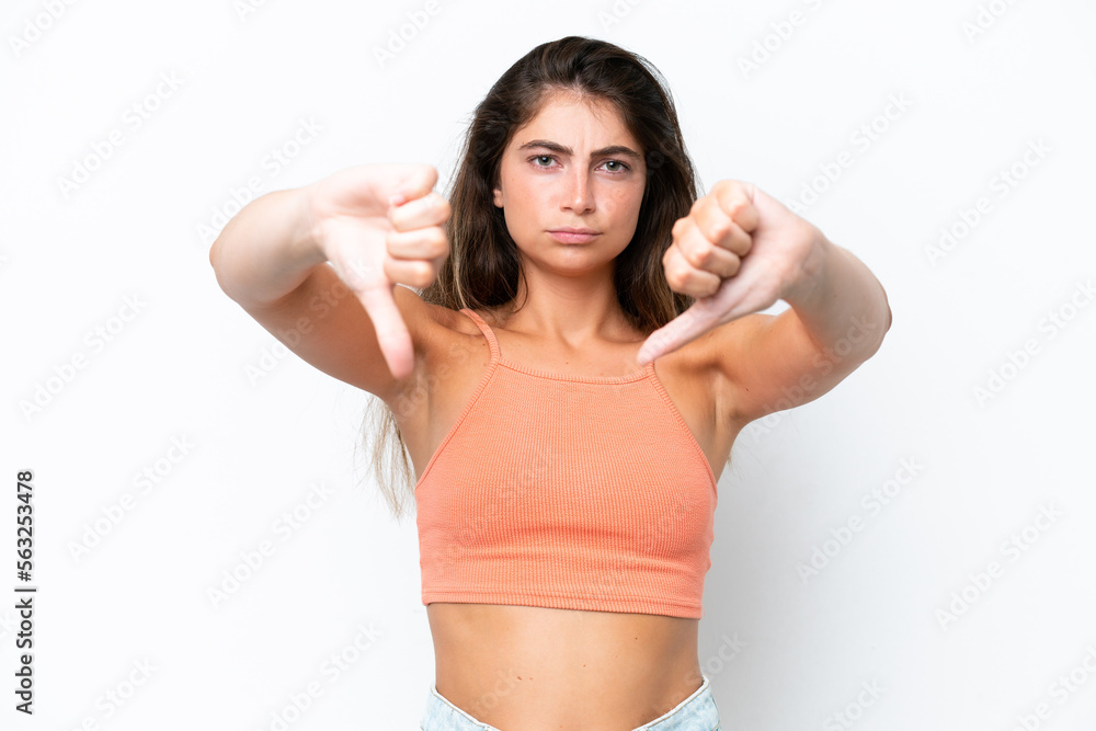 Young caucasian woman isolated on white background showing thumb down with two hands Young caucasian woman isolated on white background showing thumb down with two hands