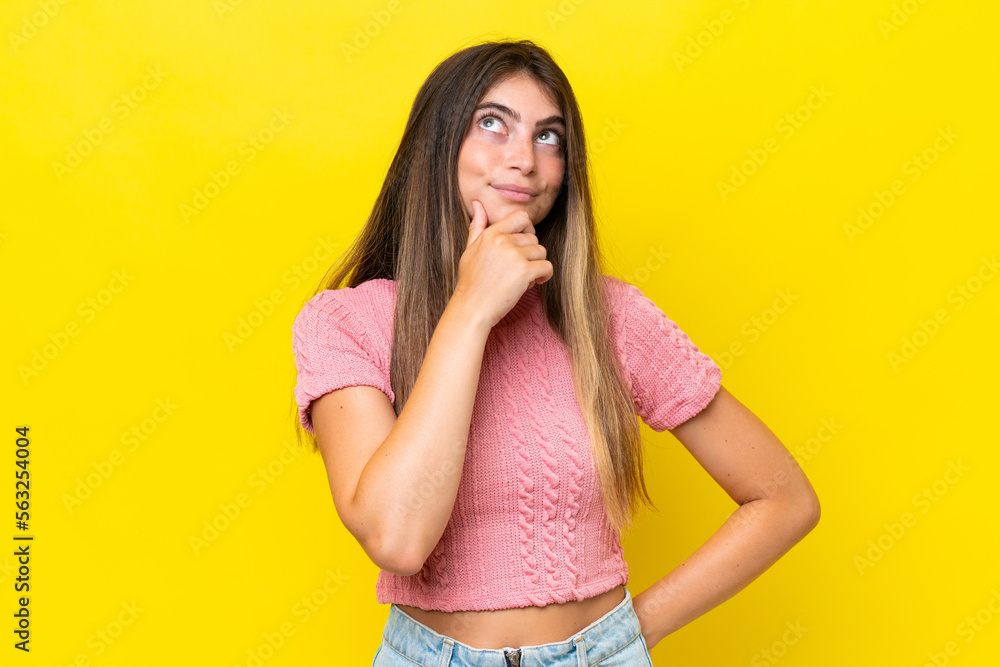 Young caucasian woman isolated on yellow background thinking an idea while looking up Young caucasian woman isolated on yellow background thinking an idea while looking up
