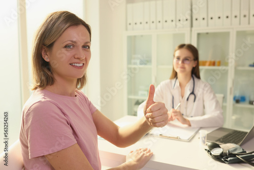 Woman patient showing thumb up at doctor appointment in clinic