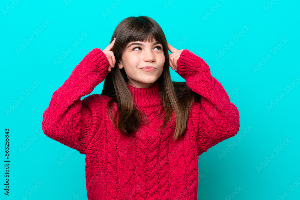 Little caucasian girl isolated on blue background having doubts and thinking Little caucasian girl isolated on blue background having doubts and thinking