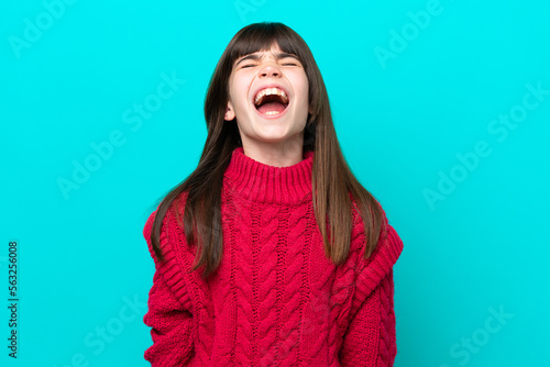 Little caucasian girl isolated on blue background shouting to the front with mouth wide open
