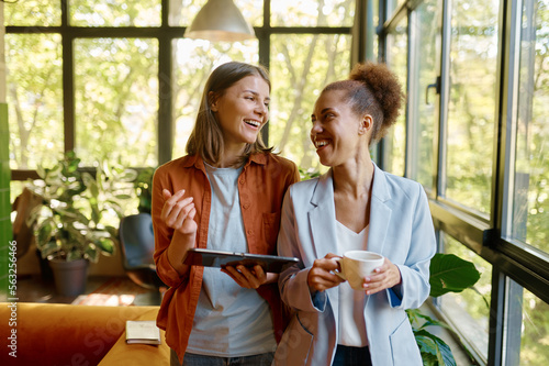 Wall Mural Happy cheerful coworkers chatting at workplace