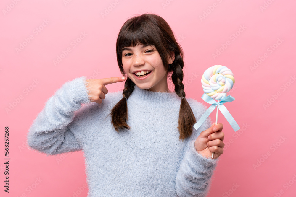 Little caucasian girl holding a lollipop giving a thumbs up gesture Little caucasian girl holding a lollipop giving a thumbs up gesture