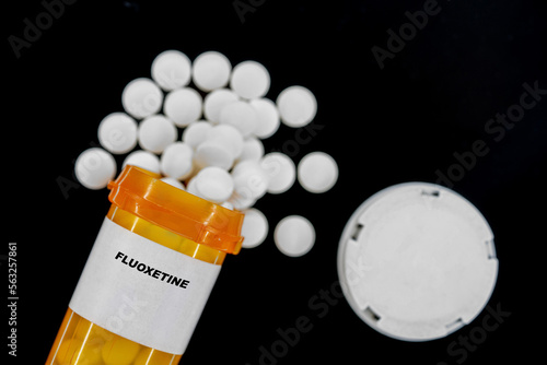 Fluoxetine Rx medical pills in plactic Bottle with tablets. Pills spilling out from yellow container. photo