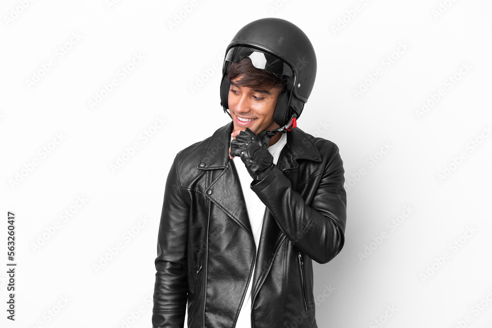 Young man with a motorcycle helmet isolated on white background looking to the side and smiling Young man with a motorcycle helmet isolated on white background looking to the side and smiling