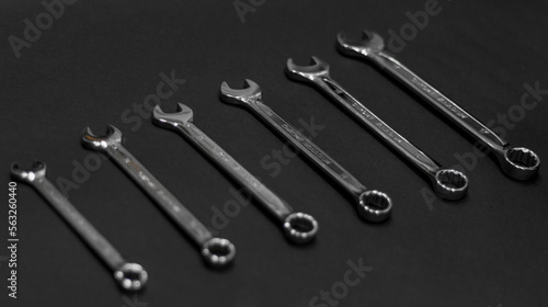 A set of wrenches made of chrome steel on a dark background lined up tools for repair and construction work and engineering. Six pieces of different sizes.