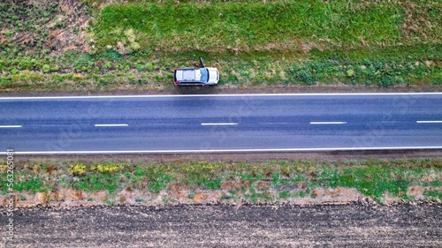 Top down drone shot of a car on the side of the road