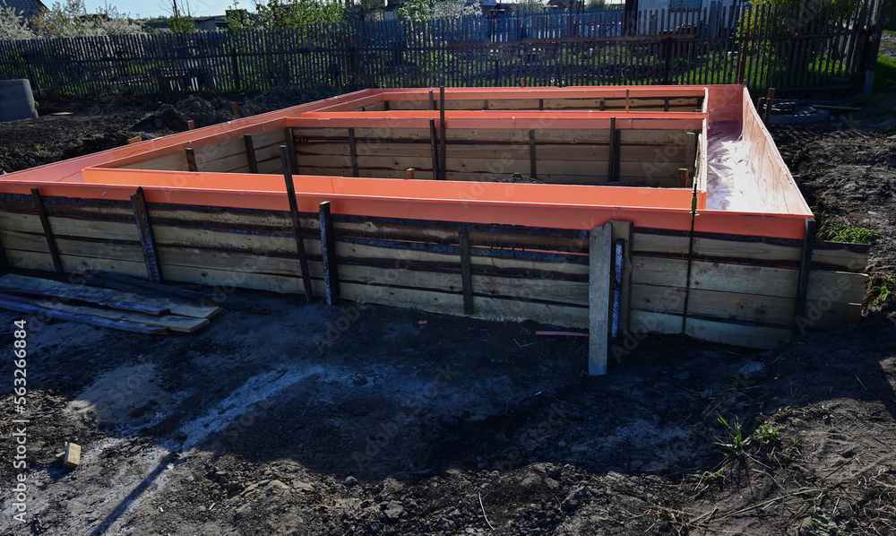 Wooden formwork with metal reinforcement prepared for pouring concrete. Installation using wire. Building a new house.