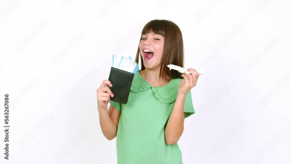 Little girl holding an airplane toy and a boarding pass over isolated background Little girl holding an airplane toy and a boarding pass over isolated background