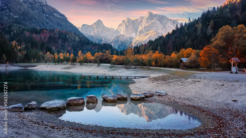 Fantastic nature scenery during sunset. Vivid autumn landscape with in the Alps with beautiful calm highland lake and mountain tops in the background. Concept of an ideal resting place. Creative image photo