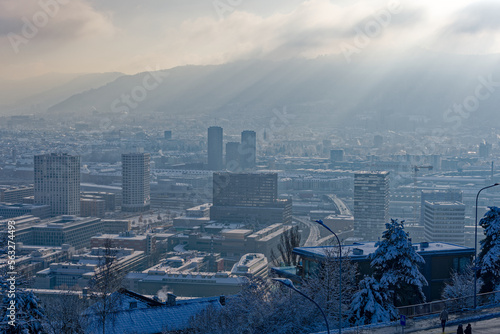 Aerial view over snow covered City of Zürich with local mountain Uetliberg in the background on a blue cloudy late autumn day. Photo taken December 11th, 2022, Zurich, Switzerland.