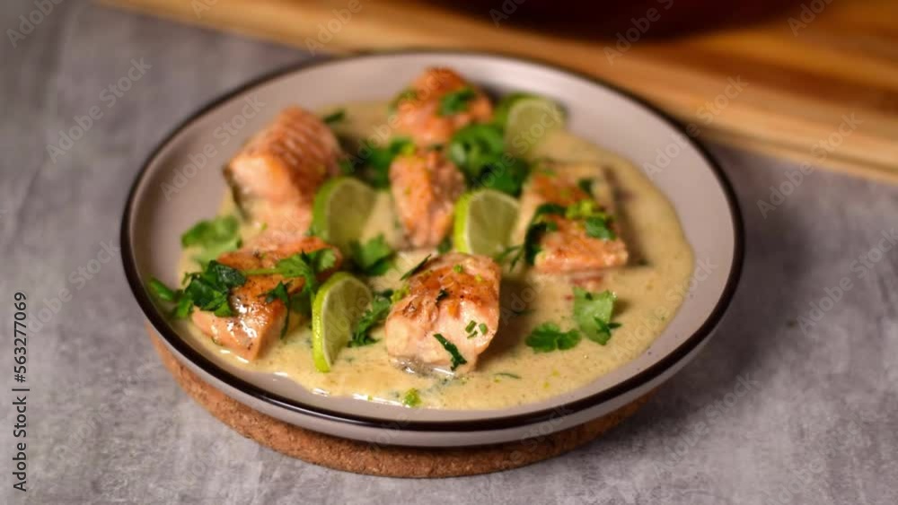 Serving trout fillet pieces in sauce with coconut milk on plate. Fish curry. Asian and Indian cuisine meal Serving trout fillet pieces in sauce with coconut milk on plate. Fish curry. Asian and Indian cuisine meal