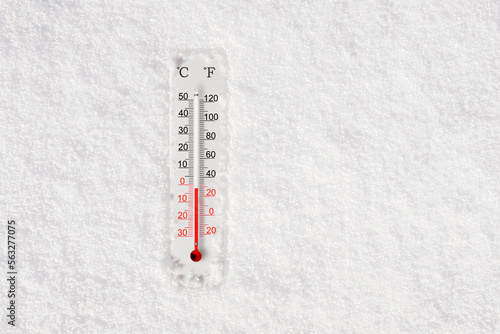 White celsius and fahrenheit scale thermometer in snow. Ambient temperature minus 2 degrees celsius