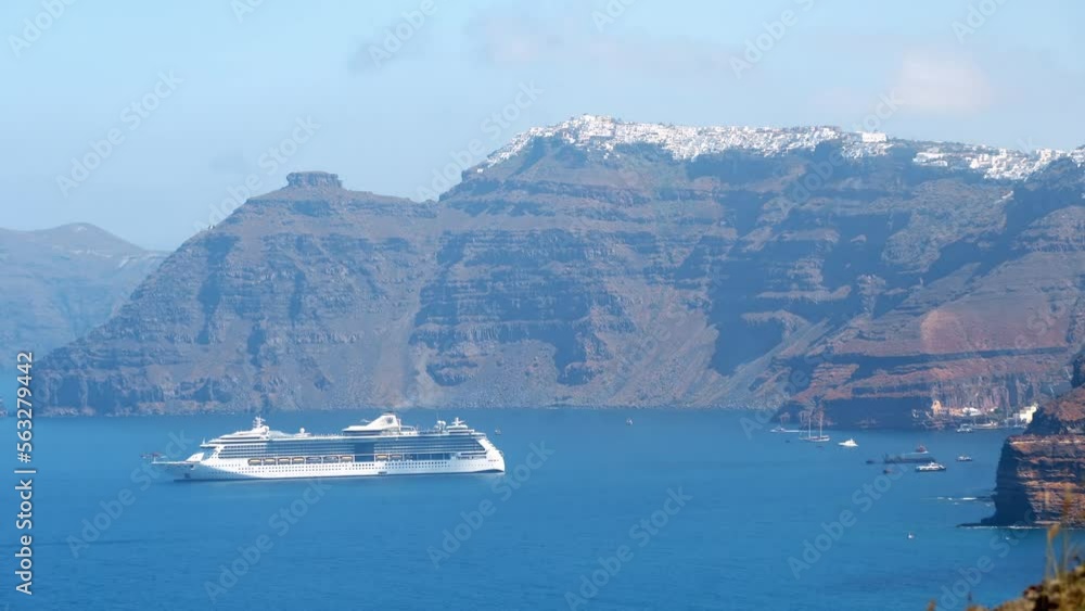 Luxury cruiser in Fira Bay, Santorini with view of Firostefany and Scaros Rock Luxury cruiser in Fira Bay, Santorini with view of Firostefany and Scaros Rock
